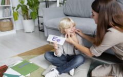 jeune-femme-faisant-de-l-orthophonie-avec-un-petit-garcon-blond