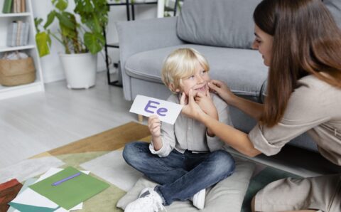 jeune-femme-faisant-de-l-orthophonie-avec-un-petit-garcon-blond