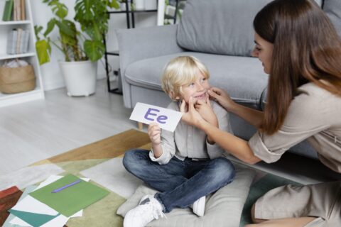 jeune-femme-faisant-de-l-orthophonie-avec-un-petit-garcon-blond