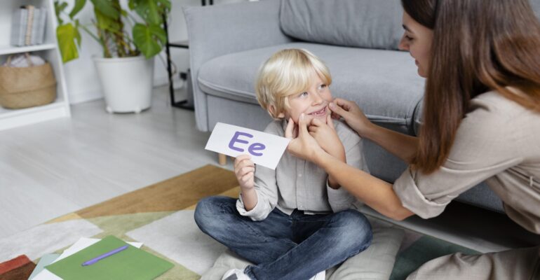 jeune-femme-faisant-de-l-orthophonie-avec-un-petit-garcon-blond