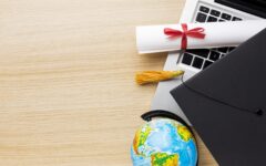 vue-de-dessus-du-globe-avec-capuchon-academique-et-ordinateur-portable