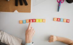 vue-de-dessus-du-tuteur-enseignant-a-l-enfant-au-bureau-les-chiffres-et-les-lettres