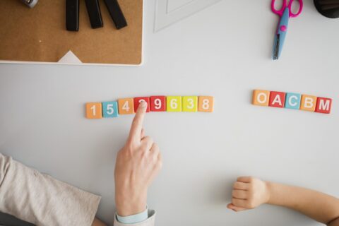 vue-de-dessus-du-tuteur-enseignant-a-l-enfant-au-bureau-les-chiffres-et-les-lettres