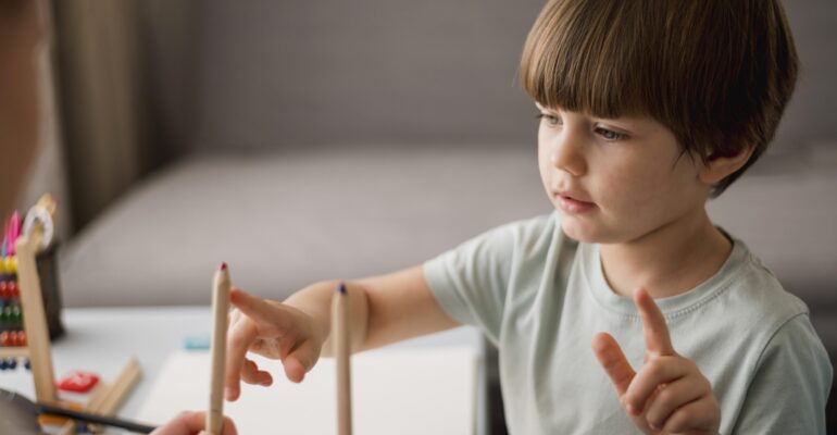 vue-laterale-d-un-enfant-apprenant-a-compter-a-la-maison-a-l-aide-de-crayons