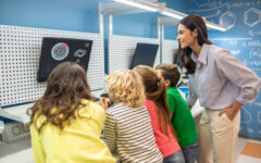 Teacher with children looking at screen at lesson
