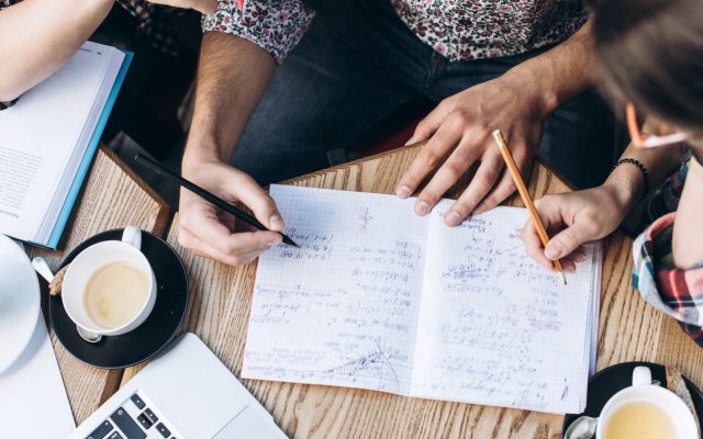 top-view-people-studying-with-copybook-book-laptop-cups-coffee-table